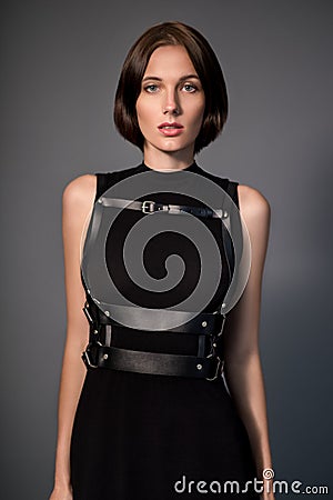 Woman in black dress with leather accessories Stock Photo