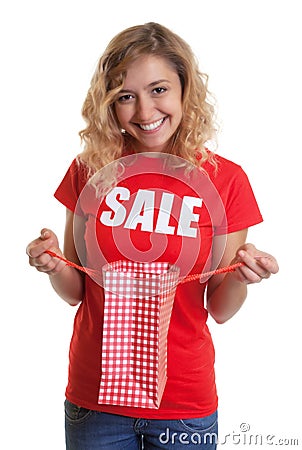 Woman with blond hair in a sales-shirt holding a shopping bag Stock Photo