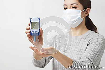 Woman with blood glucose meter, close-up Stock Photo