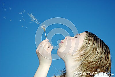 Woman blow of a dandeloin Stock Photo
