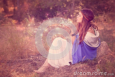 Woman blowing wishes in forest. fairy or elf Stock Photo