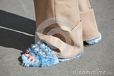 Woman with blue fur slippers and beige trousers before Genny fashion show, Milan Fashion Week Editorial Stock Photo