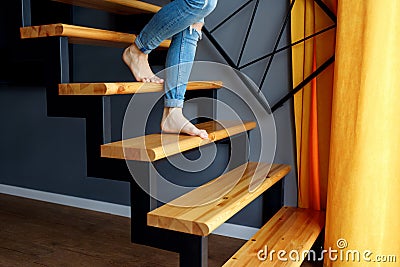 Woman in blue jeans go down in stairs. Stock Photo