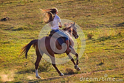 Woman in blue jeans riding a horse Stock Photo