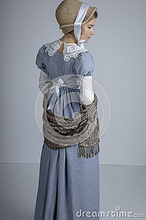 Regency woman in blue striped dress on plain background Stock Photo