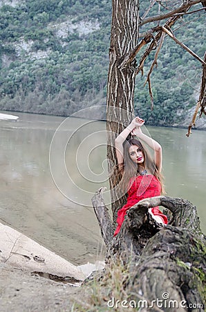 Woman in a bold red dress like a little red riding hood Stock Photo