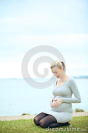 Woman bonding with unborn child Stock Photo