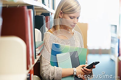 Woman, books in library and smartphone, education and research on university website for studying and knowledge. Student Stock Photo