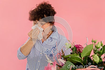 Woman bouquet of flowers hands take hankie sneezes closed eyes concept allergy illness discomfort pink background Stock Photo