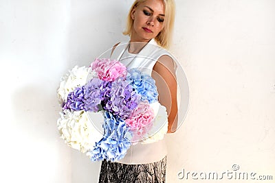 Woman with bouquet of hydrangeas. Beautiful fresh delicate flowers for holiday. Woman with beautiful flowers in her hands Stock Photo