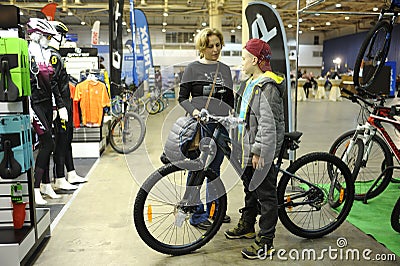 Woman and a boy standing near a bicycle just bought Editorial Stock Photo