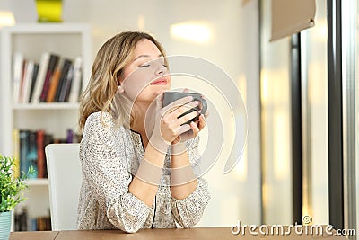 Woman breathing holding a coffee mug at home Stock Photo