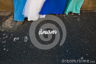 Woman bride maids in colorful blue dresses stand by a sign. Dream Stock Photo