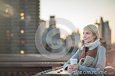 Woman on the Brooklyn Bridge Looking at Manhattan with a Coffee Stock Photo