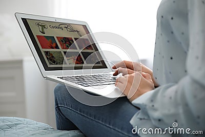 Woman browsing cooking blog on laptop at home Stock Photo