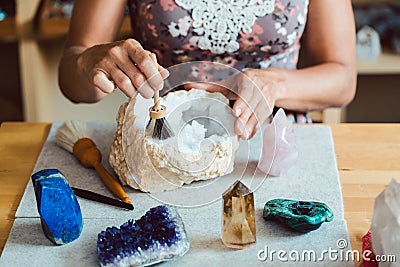 Woman brushing and dusting various gemstones Stock Photo