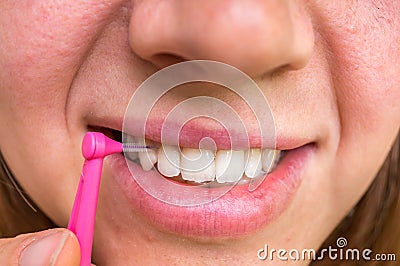 Woman brushing her teeth with interdental brush Stock Photo