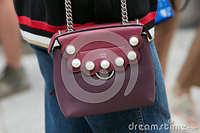 Woman with burgundy Fendi leather bag before Emporio Armani fashion show, Milan Fashion Week Editorial Stock Photo