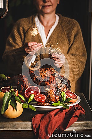 Woman burning sparkles over Christmas whole roasted turkey Stock Photo