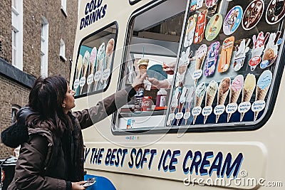Woman buying ice-cream from Mr. Whippy van in Covent Garden, London, UK. Editorial Stock Photo