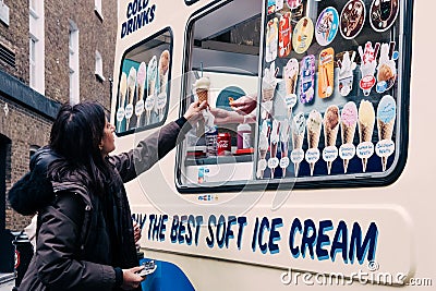 Woman buying ice-cream from Mr. Whippy van in Covent Garden, London, UK. Editorial Stock Photo