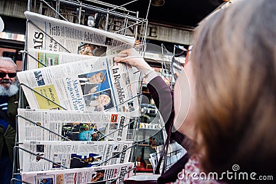Woman buying international press with Emmanuel Macron and Marine Editorial Stock Photo