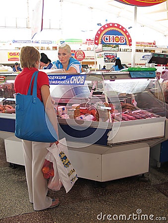 A woman buying meat for sale in the Komarovsky marketplace, Minsk Belarus Editorial Stock Photo