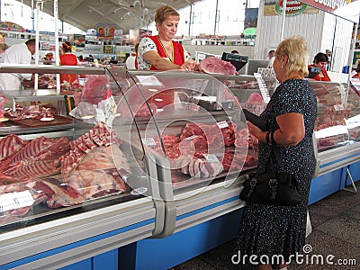 A woman buying meat for sale in the Komarovsky marketplace, Minsk Belarus Editorial Stock Photo