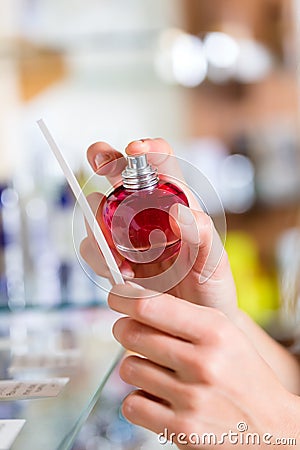 Woman buying perfume in shop or store Stock Photo