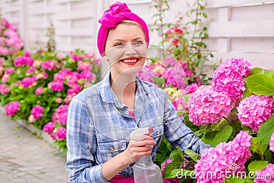 Woman care of flowers in garden. happy woman gardener with flowers. Greenhouse flowers. hydrangea. Spring and summer Stock Photo