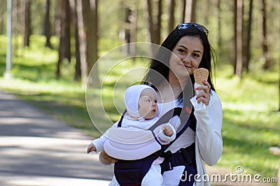 Woman caring child in baby carrier Stock Photo
