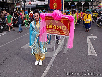 A woman carries a banner in the parade in a Festival of the Clans of the Chinese community of Bangkok Editorial Stock Photo