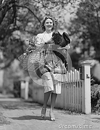 Woman carrying live turkey and grocery basket Stock Photo