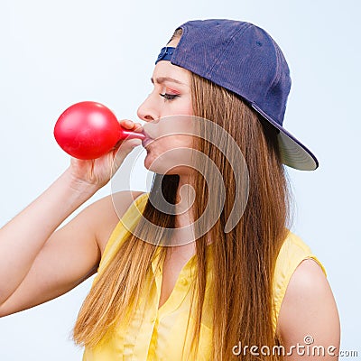 Woman casual style blowing up a red balloon Stock Photo