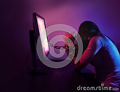 Woman chained to computer Stock Photo