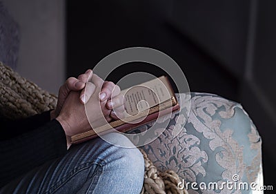 Woman on a chair with her Christian book Stock Photo