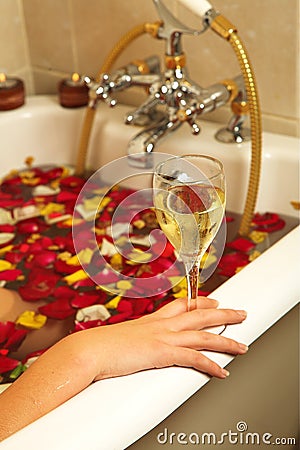 Woman with Champaign and rose petals Stock Photo