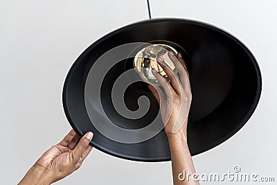 Woman is changing a lightbulb Stock Photo