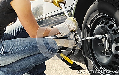 Woman changing tire car Stock Photo