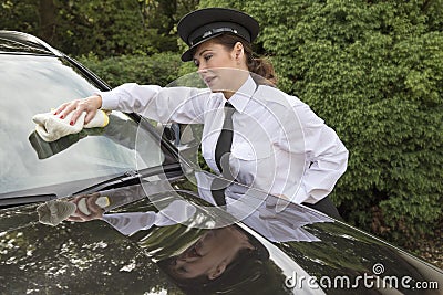 Woman chauffeur polishing car window Stock Photo