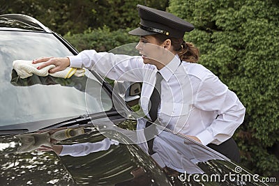 Woman chauffeur polishing car window Stock Photo