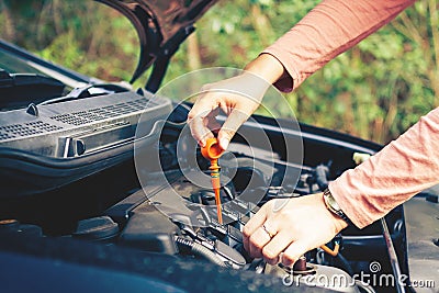 Woman check the engine oil of the car Stock Photo