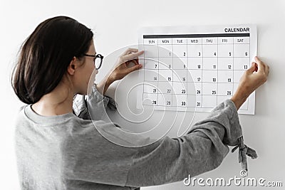 Woman checking the calendar on wall Stock Photo