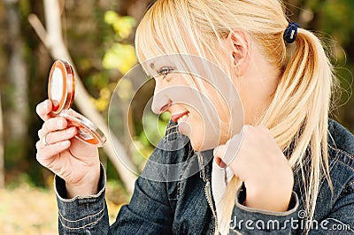 Woman checking hair in mirror Stock Photo