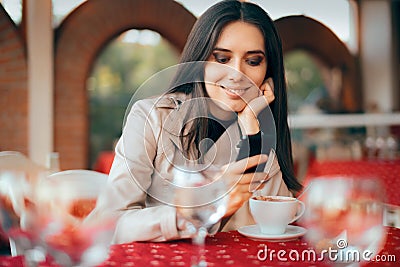 Woman Checking Her Smartphone in a Restaurant Stock Photo