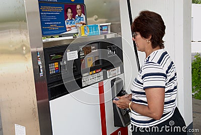 Woman checking prices of gasoline at the gas pumps in Belleviille, Michigan Editorial Stock Photo