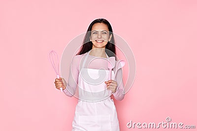 woman in chef apron in whose pocket a whisk and a spatula Stock Photo