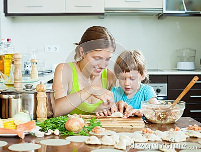 Woman with child cooking fish pelmeni (pelmeni), always together Stock Photo