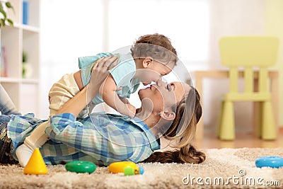 Woman with baby playing together on cozy carpet at home Stock Photo