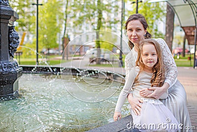 Woman with child playing against splashes of water in the summer Stock Photo